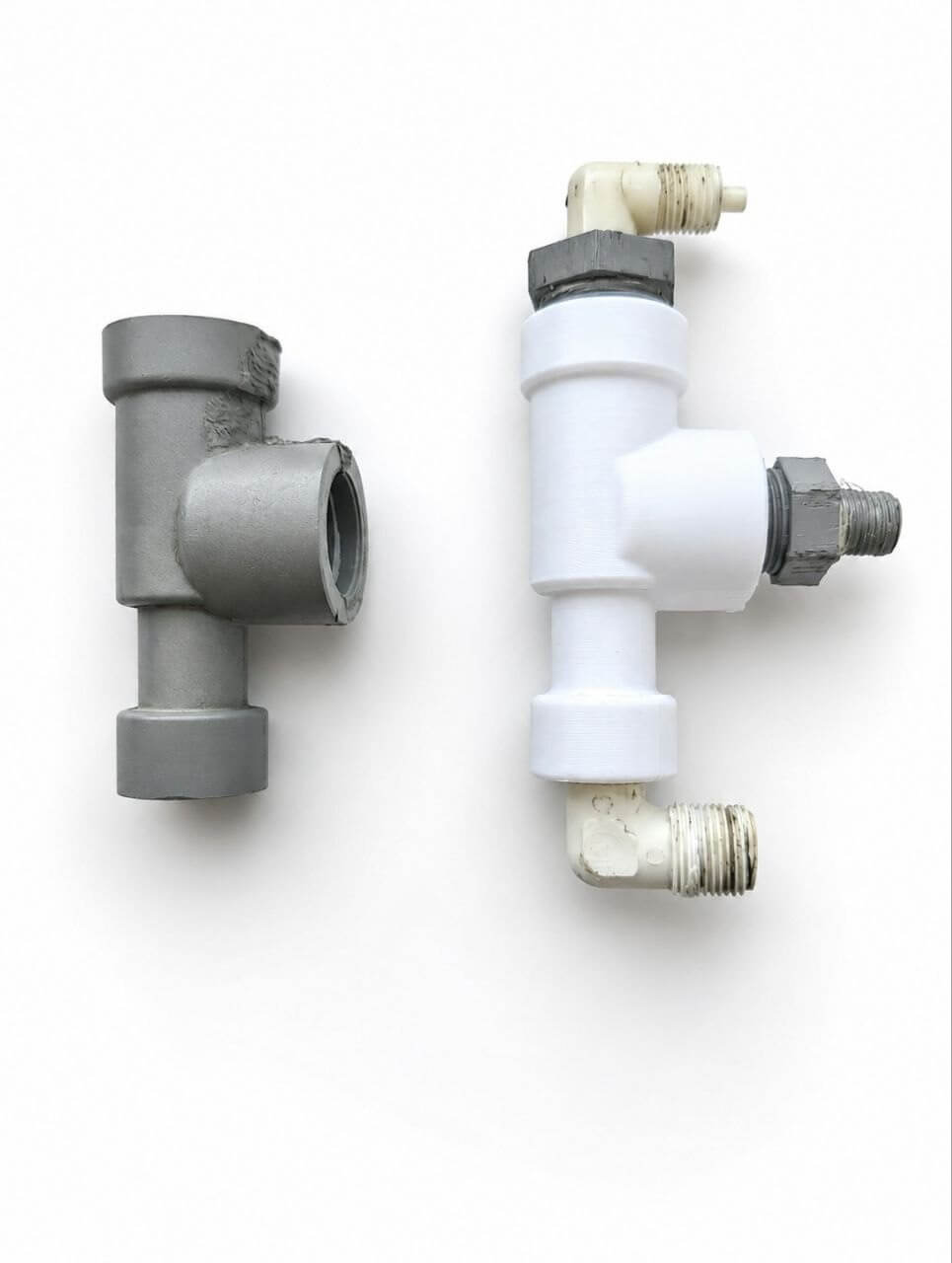 White 3D-reproduced T-fitting beside the original gray metal fitting