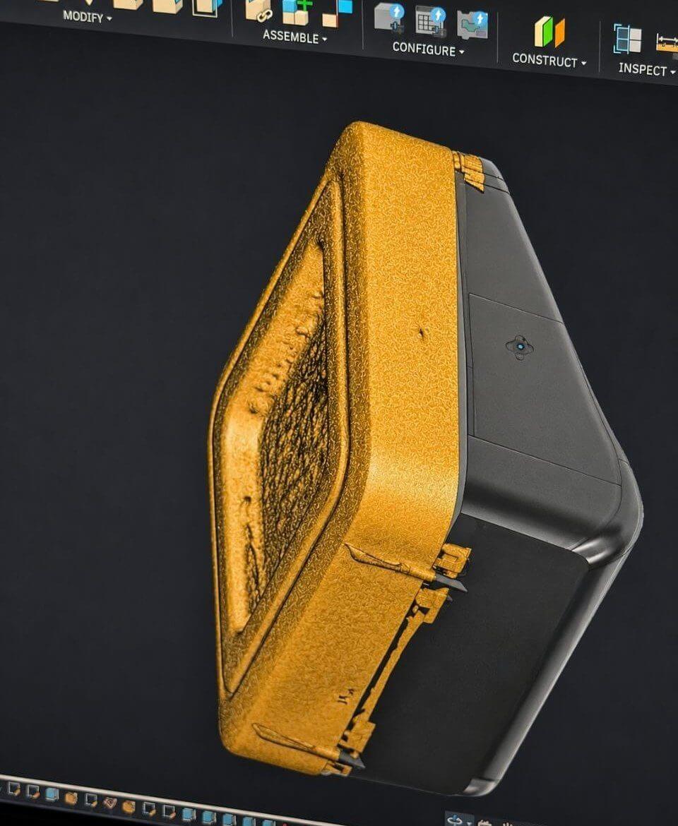 Golden 3D scan of a housing overlaid on the original CAD model