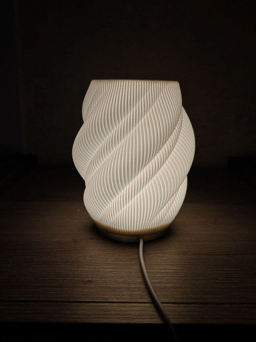 3D-printed lamp with warm light diffusing through textured walls