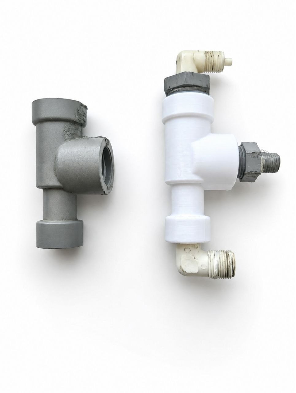 White 3D-reproduced T-fitting beside the original gray metal fitting