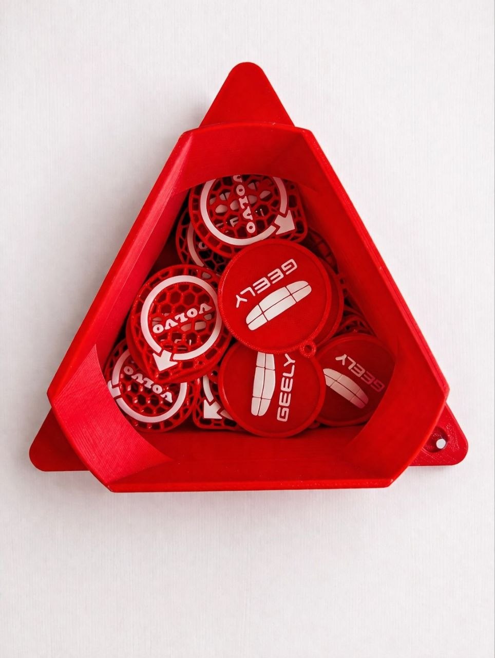 Red triangular container with Geely branded tokens